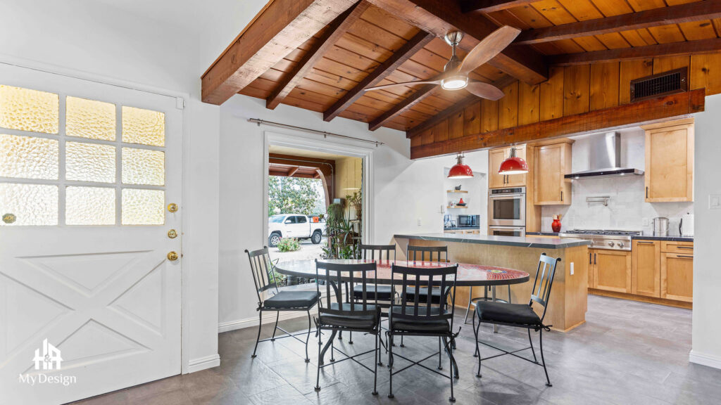 Open dining area and kitchen under a wood-beam ceiling in the Northridge renovation project