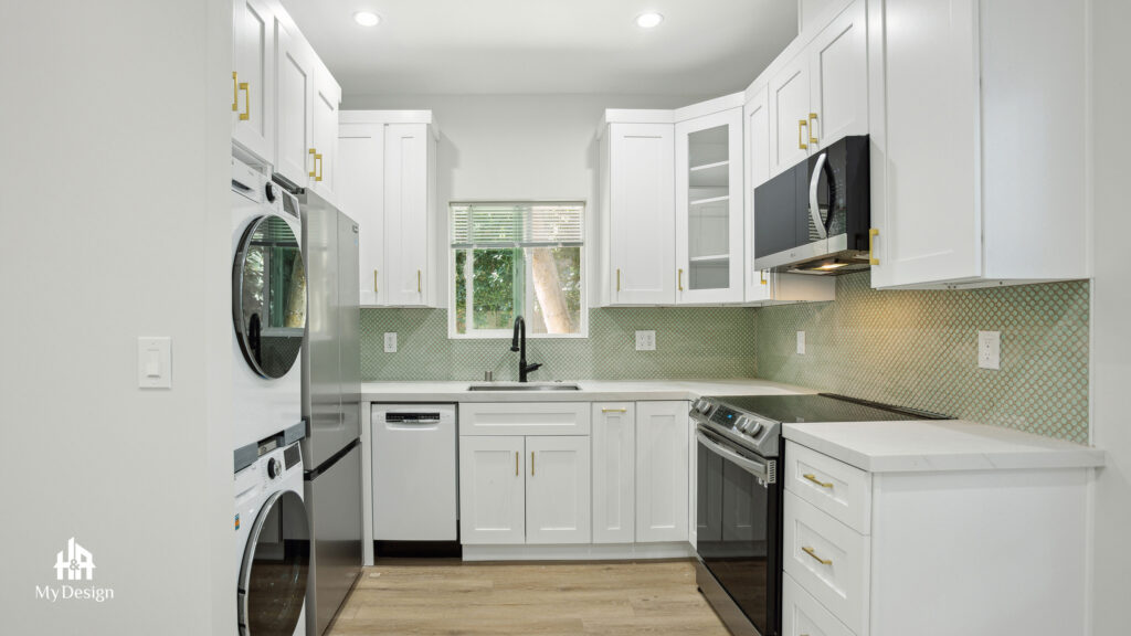 ADU kitchen with white shaker cabinets, green tile backsplash and a stacked washer-dryer