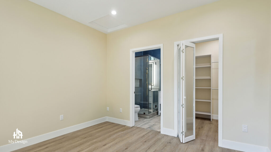 ADU bedroom with a bi-fold closet opening directly into its ensuite bathroom
