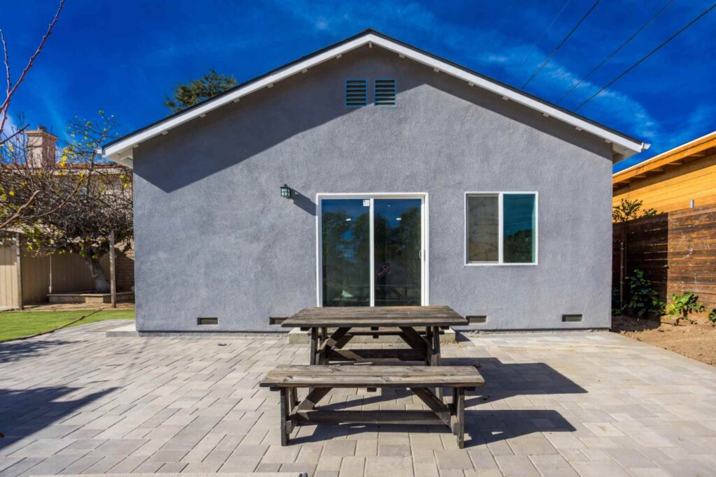 Rear exterior of the detached Los Alimos ADU with a paved patio