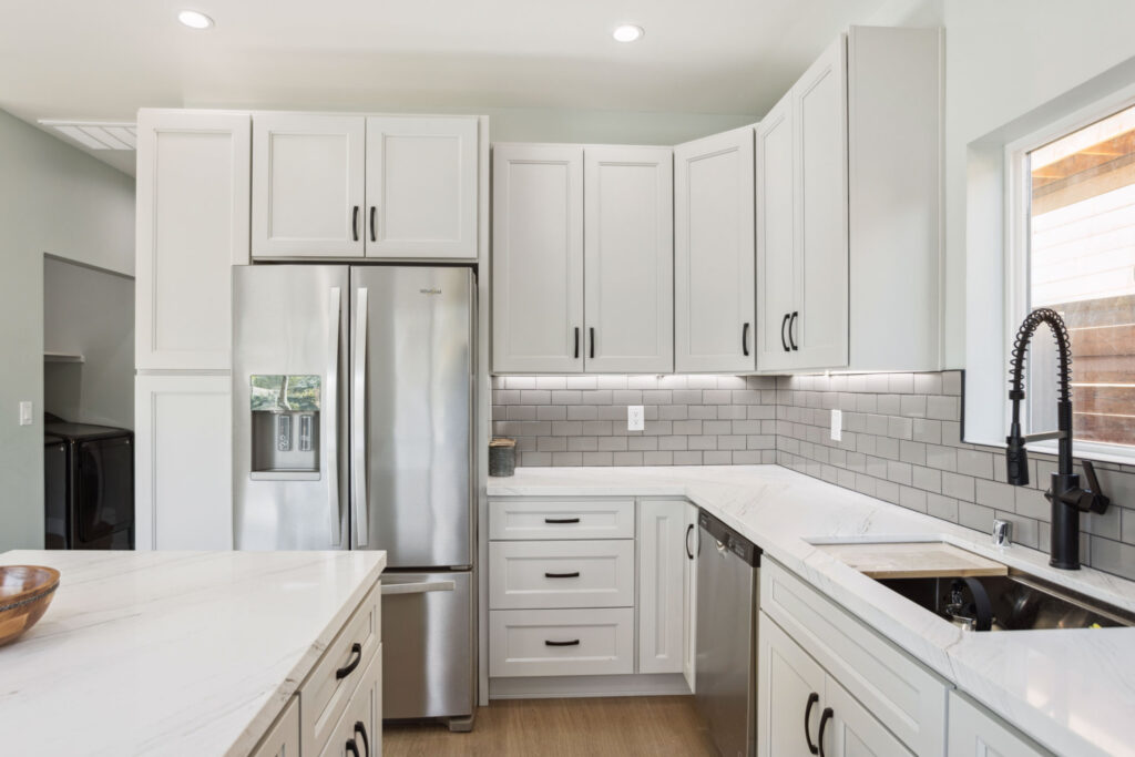 Galley kitchen run in the Los Alimos ADU with quartz counters and tile backsplash