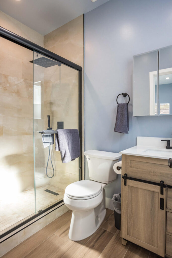 ADU bathroom with a glass walk-in shower, wood vanity and vessel basin
