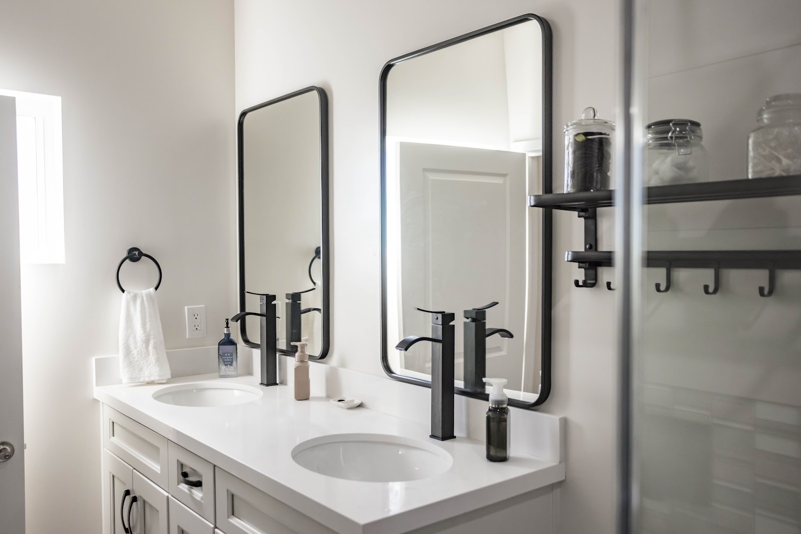 ADU bathroom double vanity with black framed mirrors and black faucets