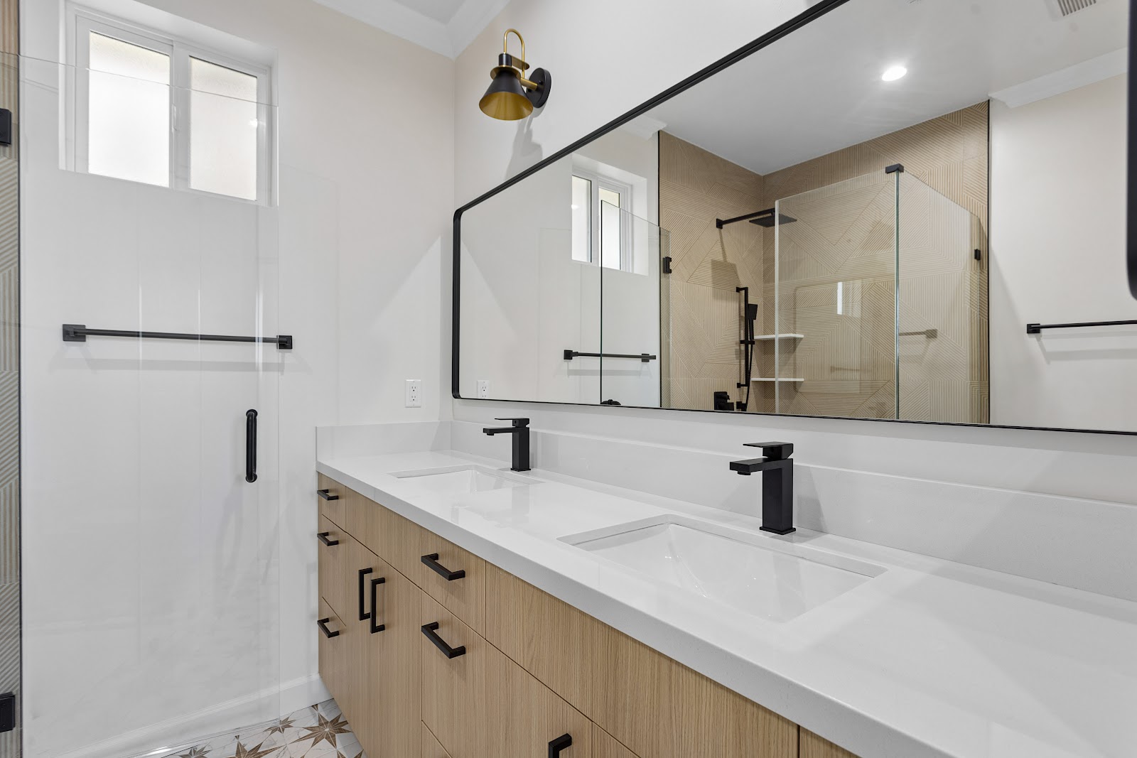 ADU bathroom with an oak double vanity over patterned star tile