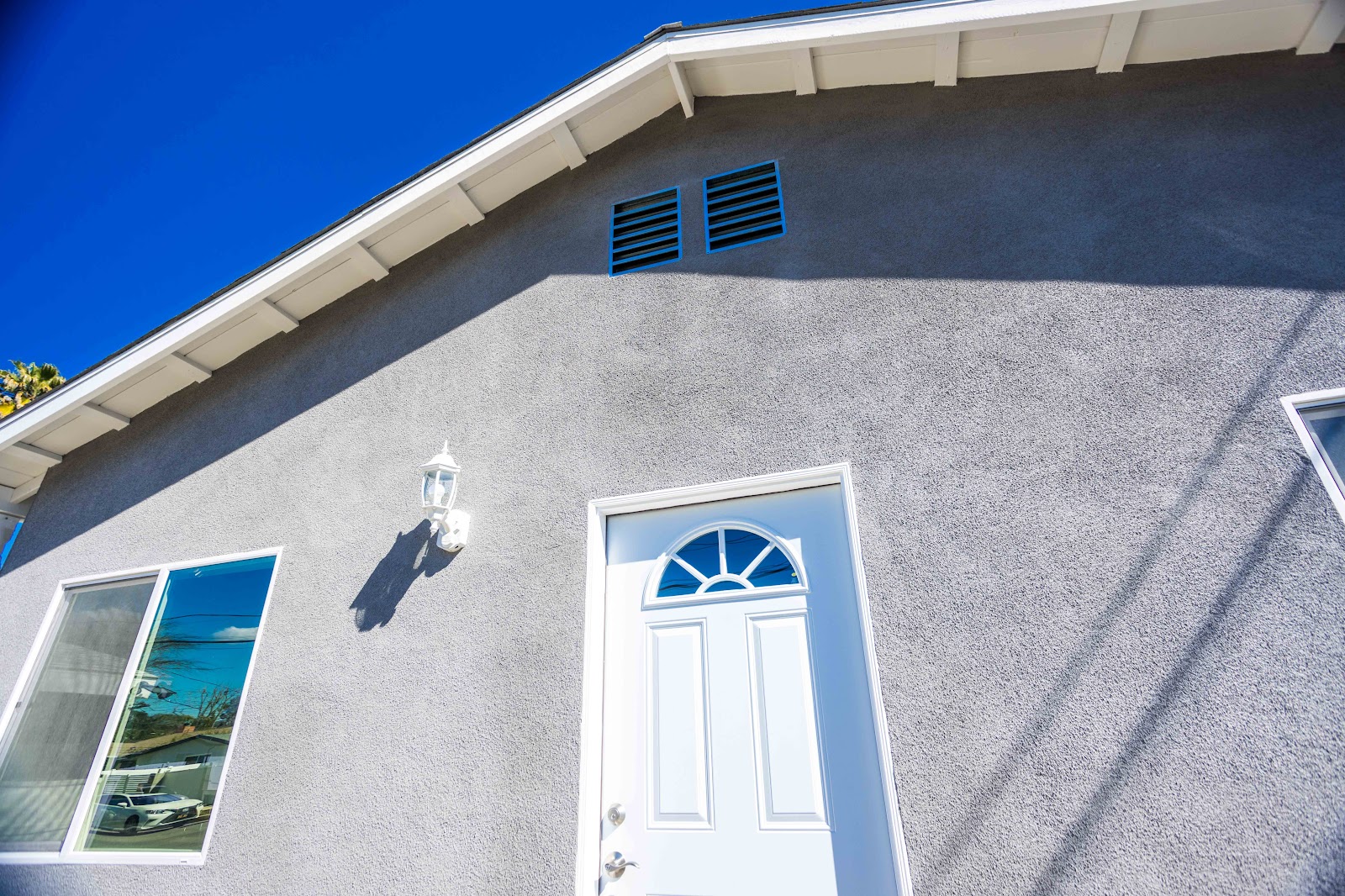 ADU entry door and stucco wall detail with exterior lighting