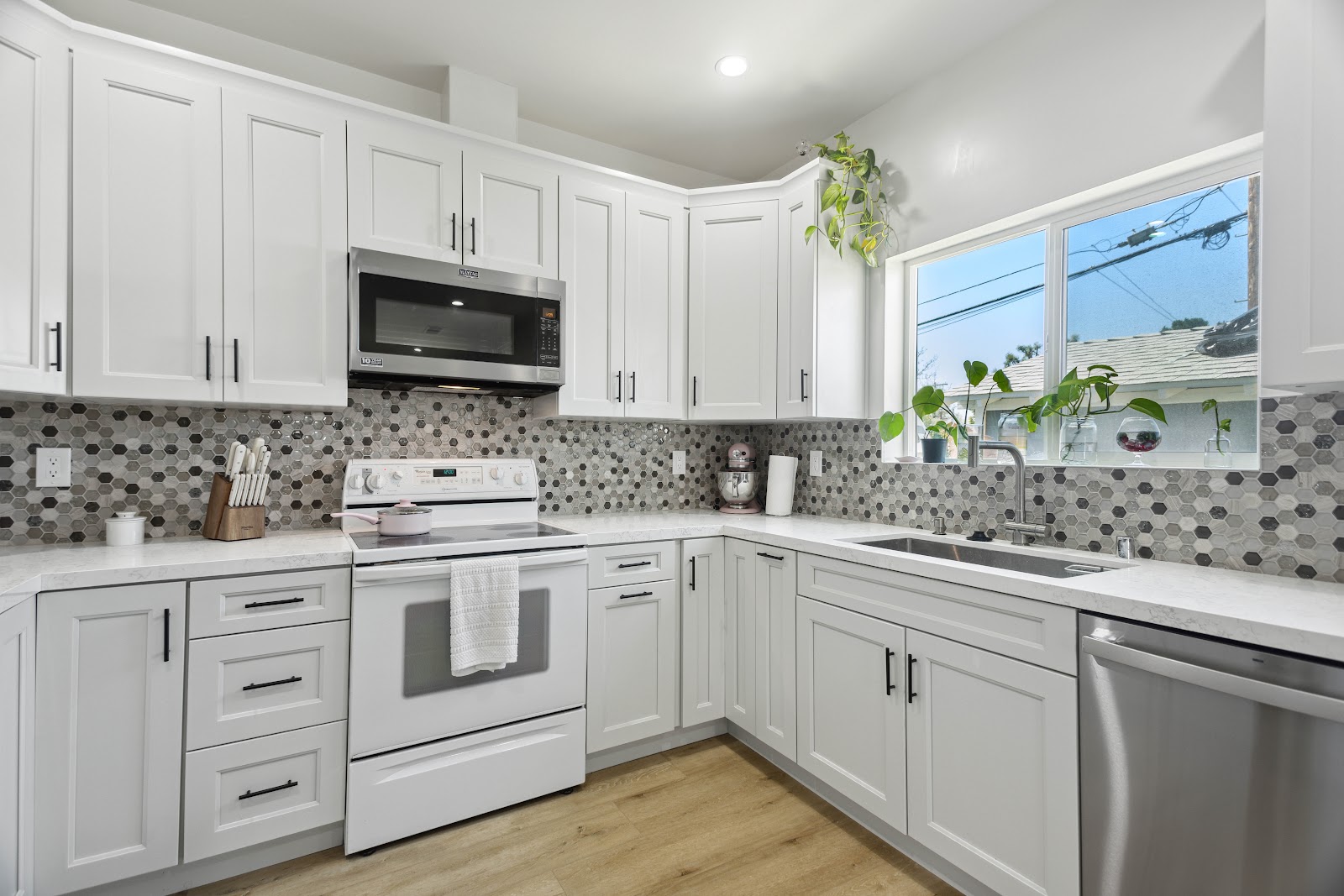 L shaped ADU kitchen layout with a window over the counter