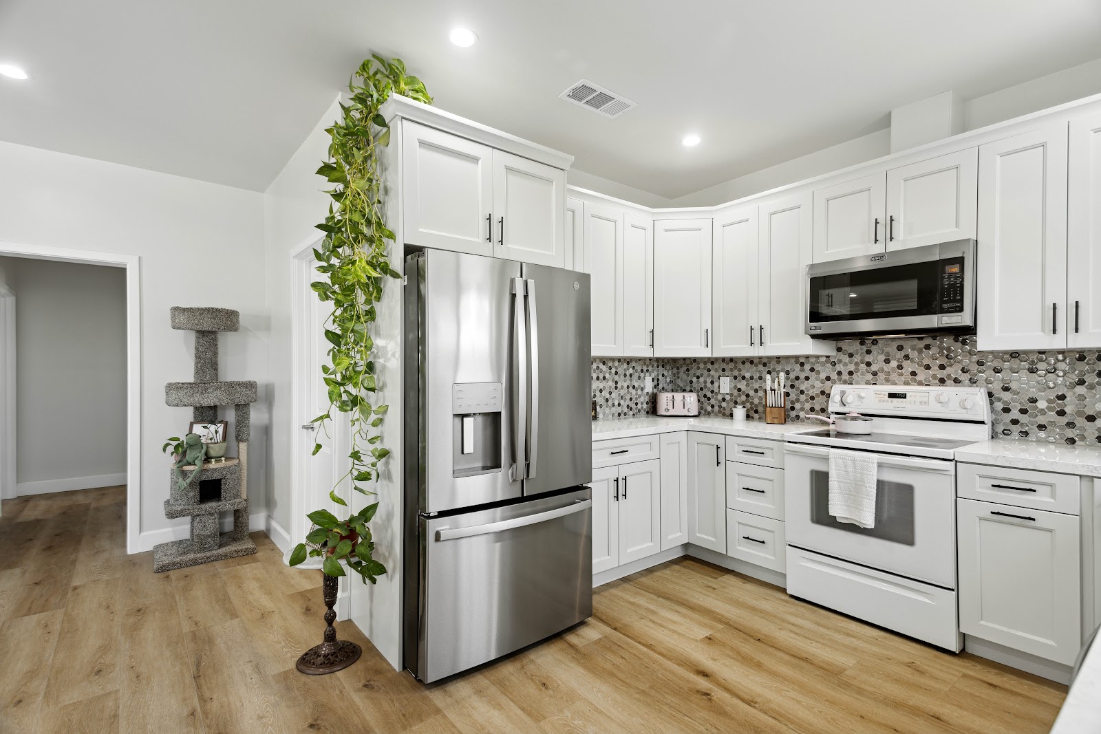 ADU kitchen under a vaulted ceiling with a full height refrigerator