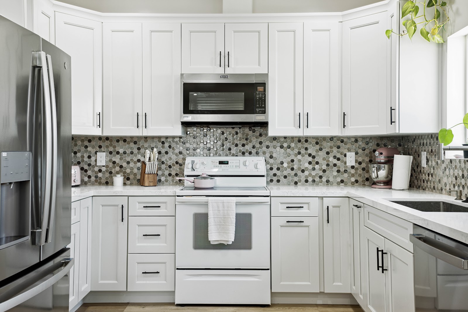 ADU kitchen with white shaker cabinets and a glass mosaic backsplash