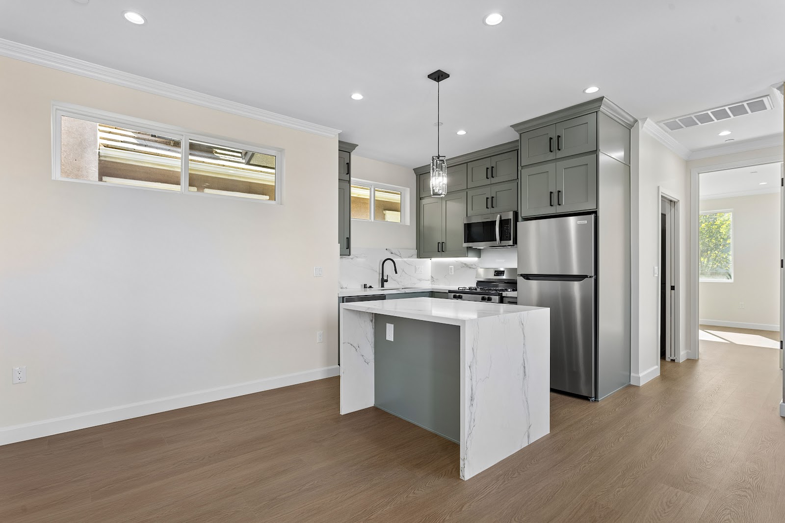 Backyard ADU kitchen and living space with a fluted timber feature wall