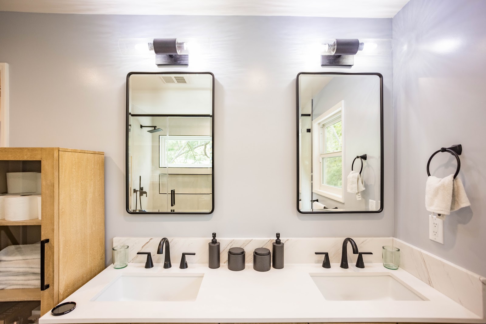 Bathroom double vanity with black framed mirrors and matte black faucets