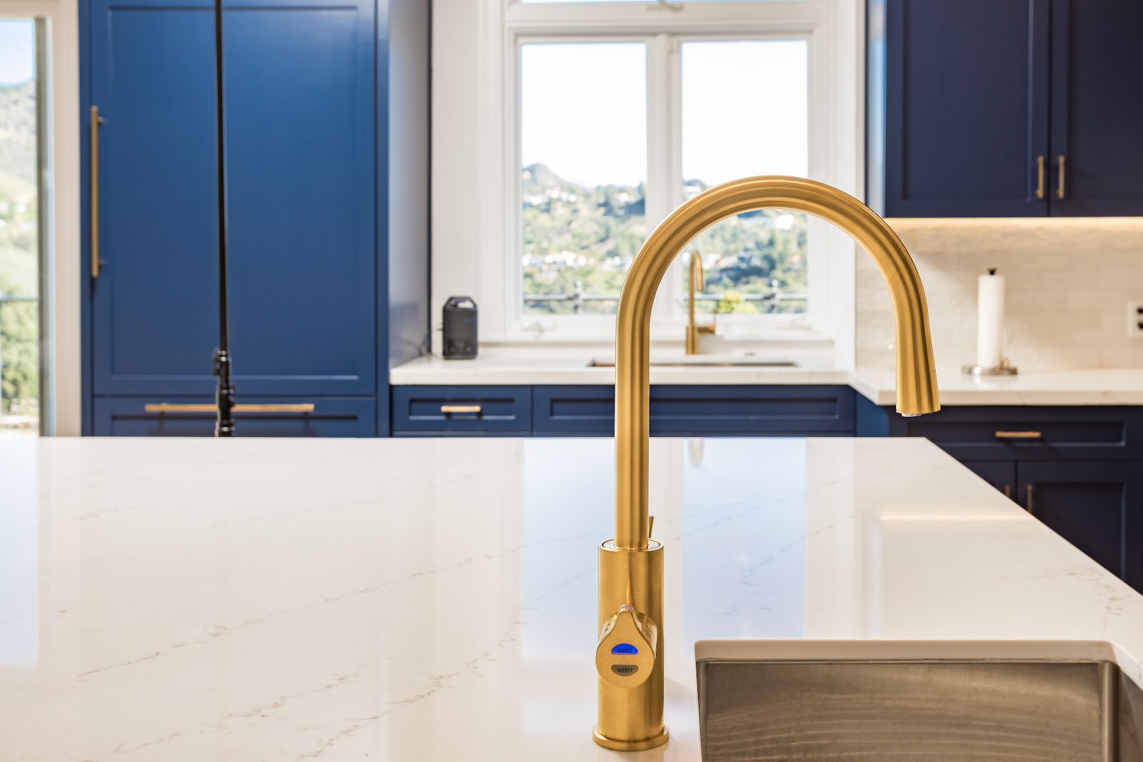 Brass gooseneck faucet detail on a quartz island