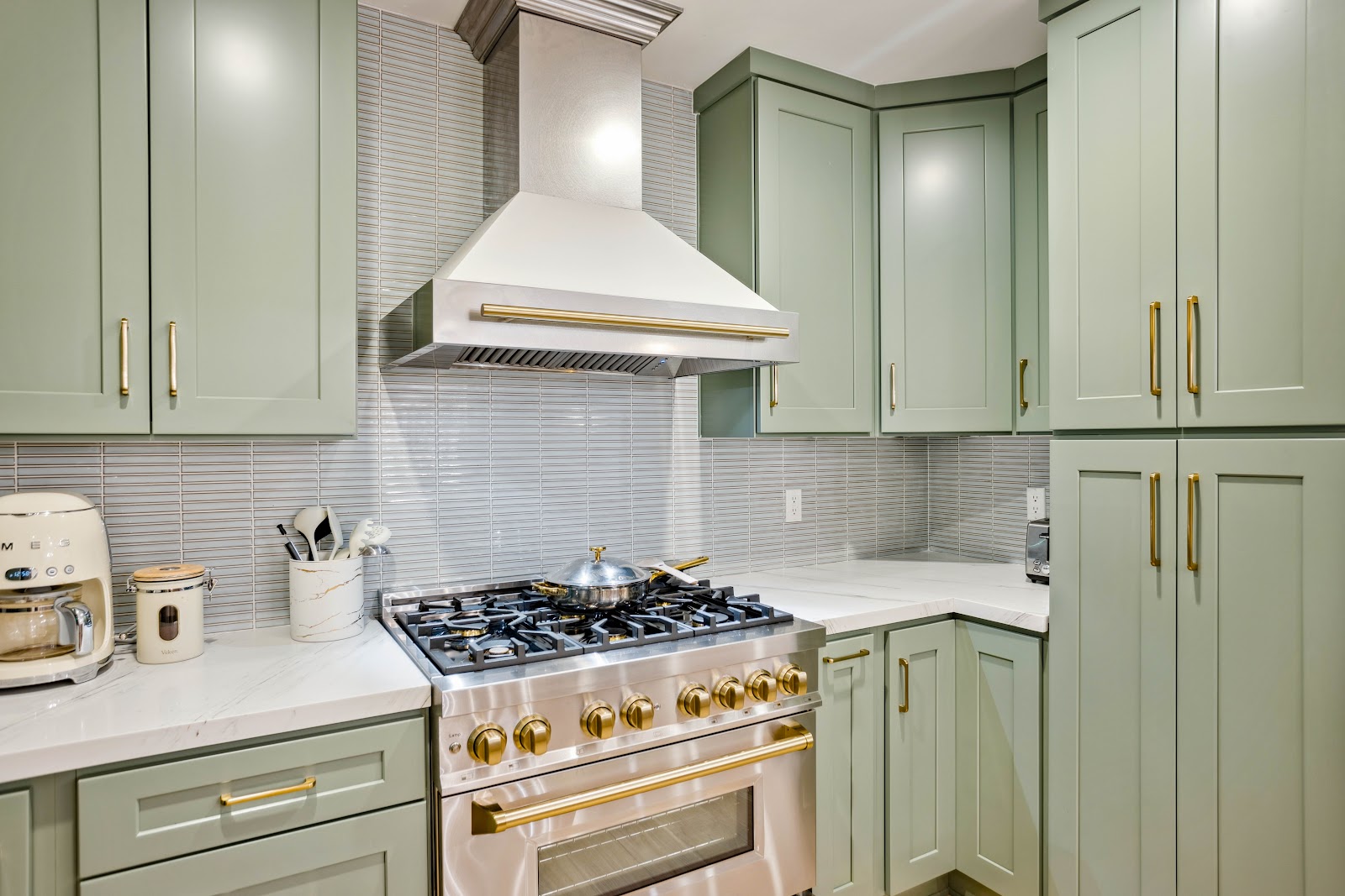 Brass trimmed range against a stacked grey tile backsplash