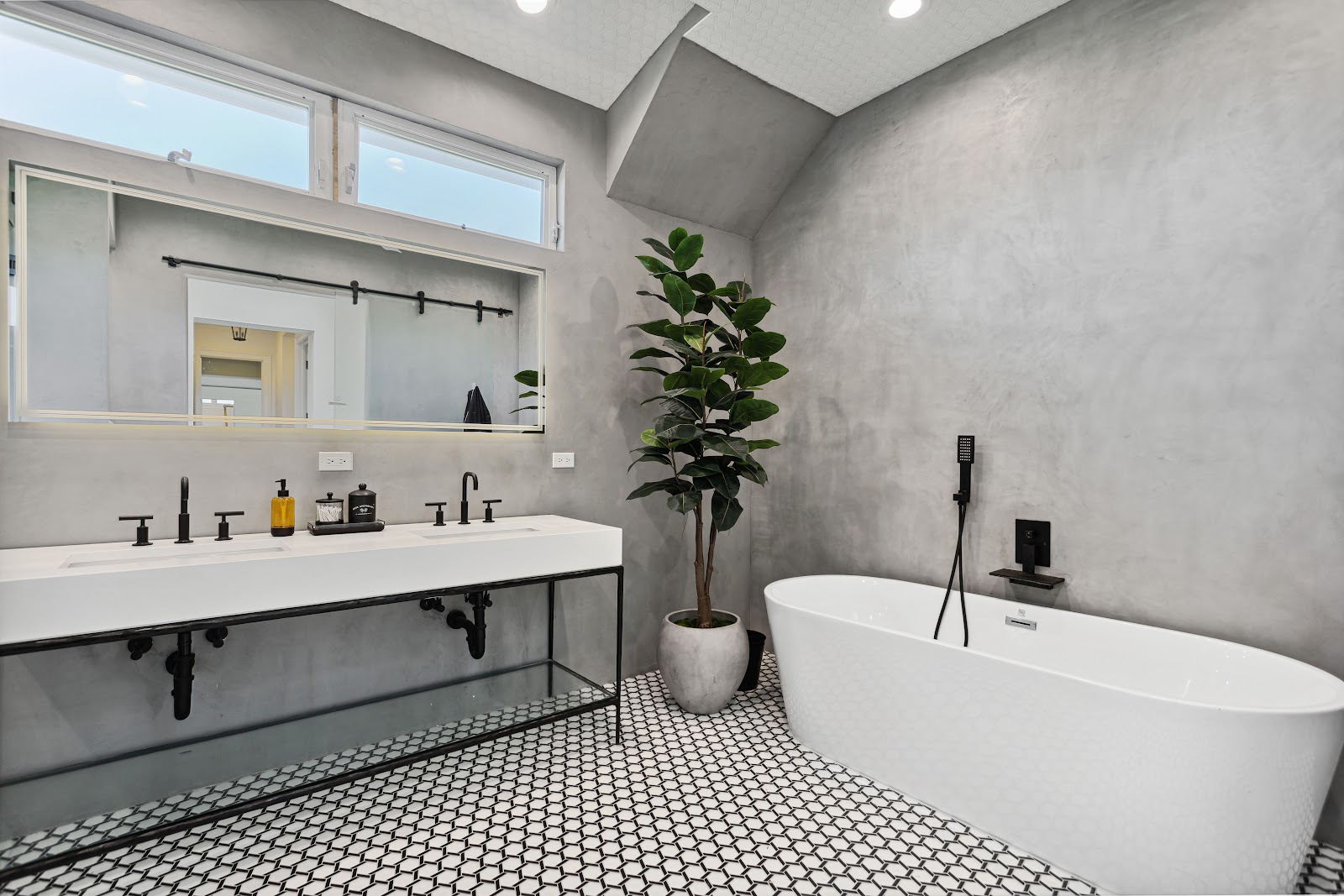 Freestanding tub on a black and white mosaic floor in a spa bathroom