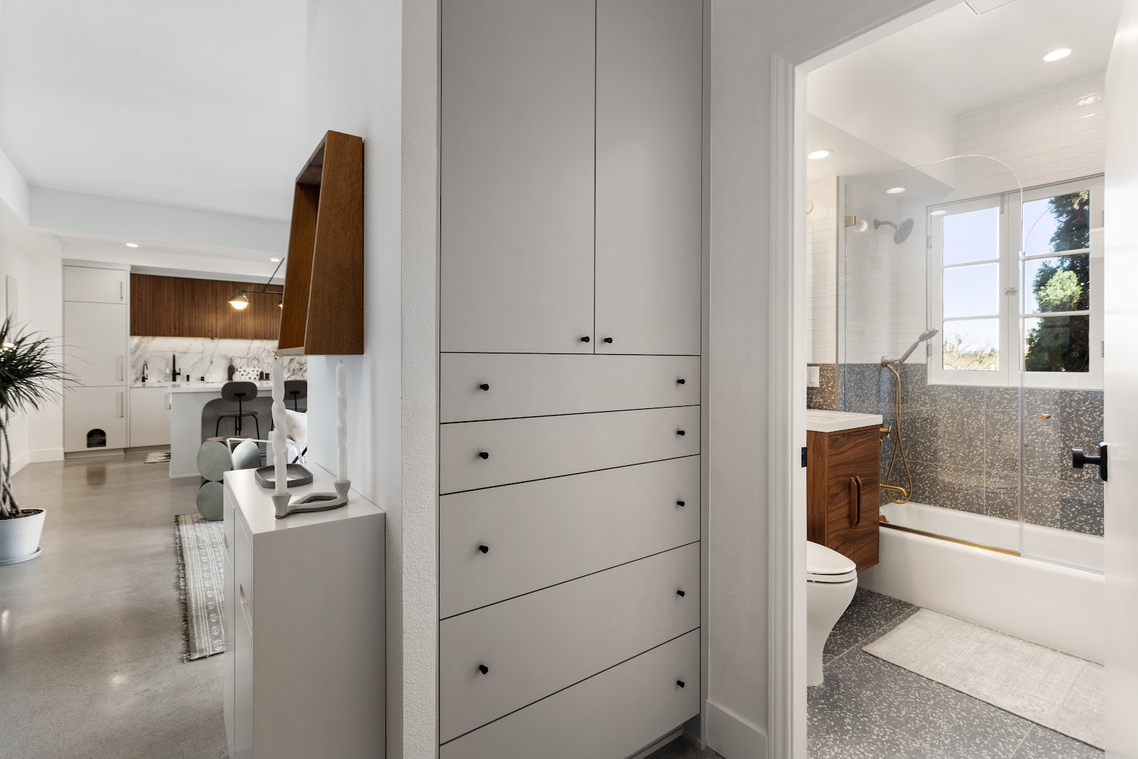 Hallway with built-in drawer storage leading through to the bathroom