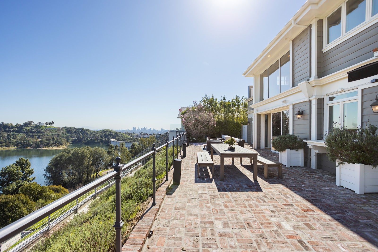 Hillside home exterior with a paver terrace and a long valley view