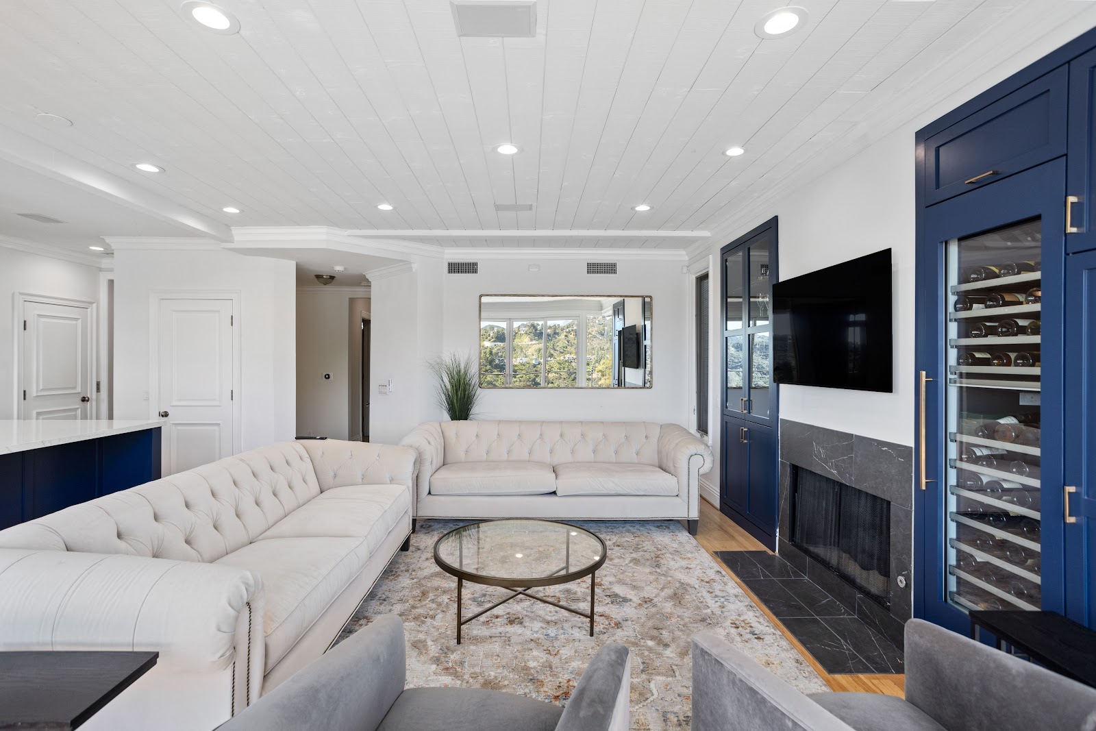 Living room with navy built in cabinetry either side of a fireplace