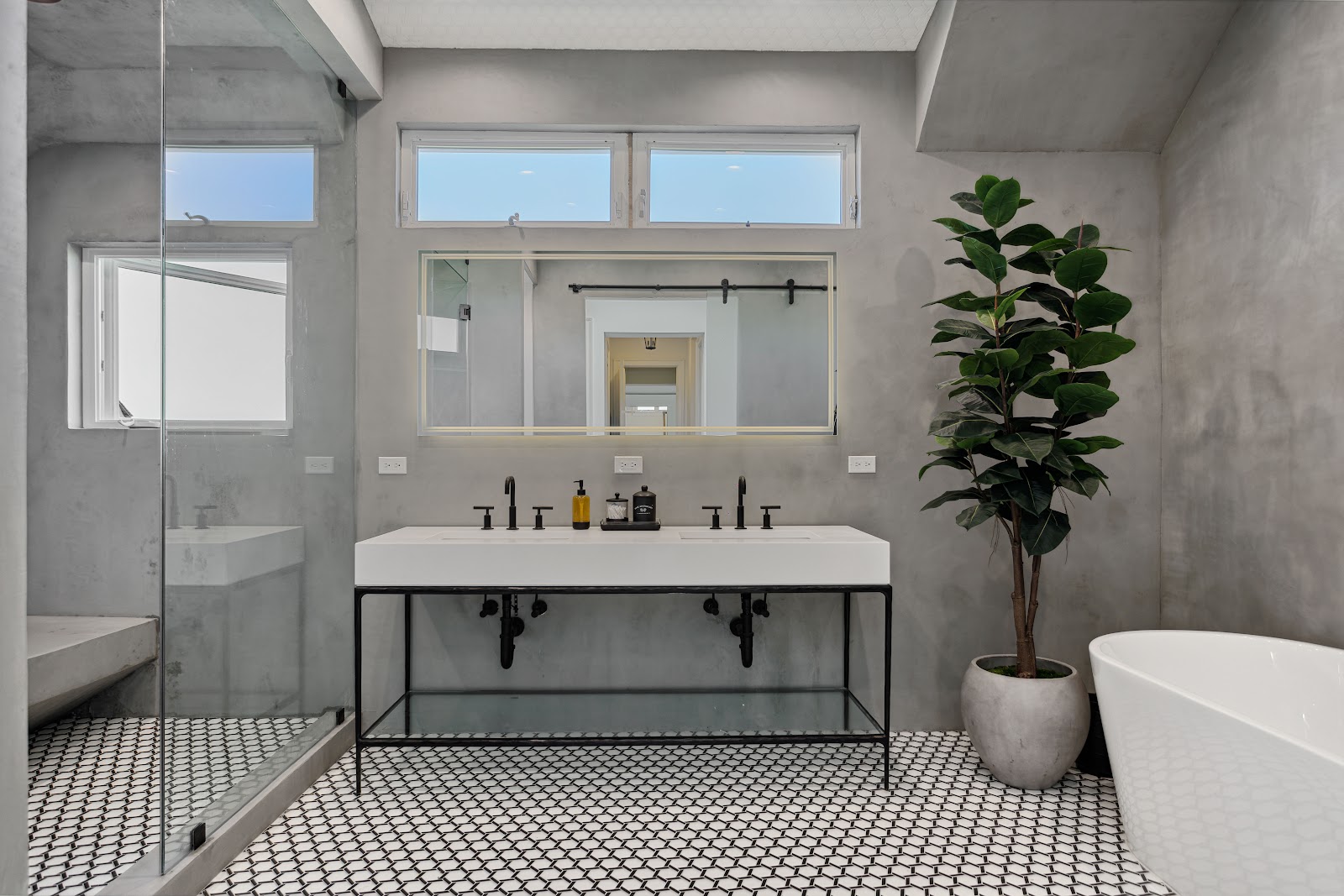 Microcement spa bathroom with a double trough sink on a black steel frame