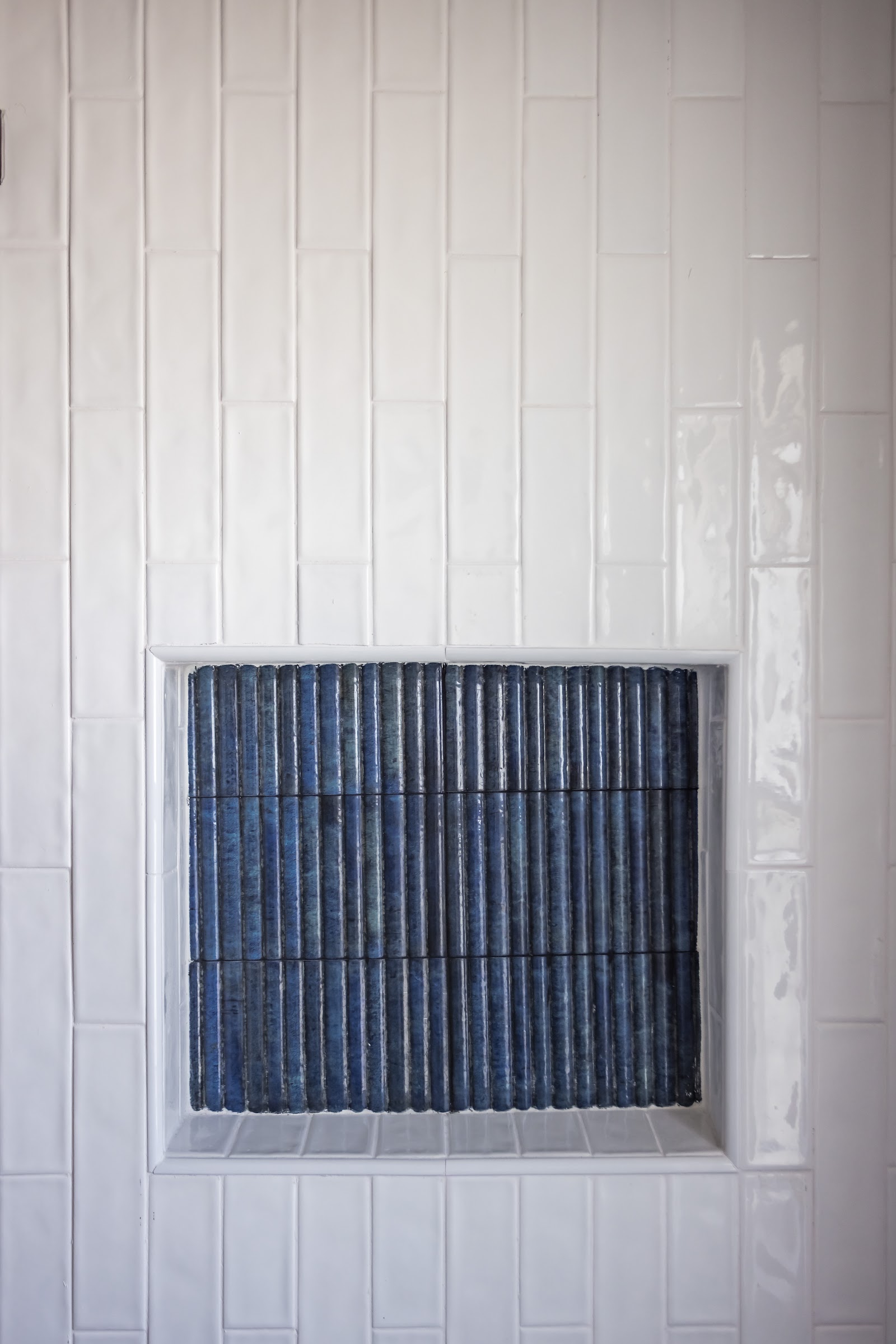 Mudroom bench with shoe cubbies and coat hooks beside the entry