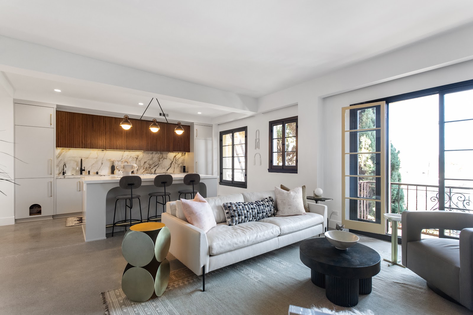 Open plan living room looking through to the remodeled kitchen and balcony doors