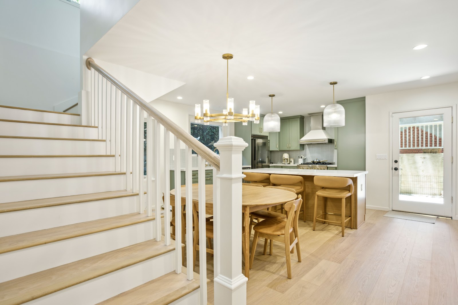 Staircase with oak treads and white risers under a brass chandelier
