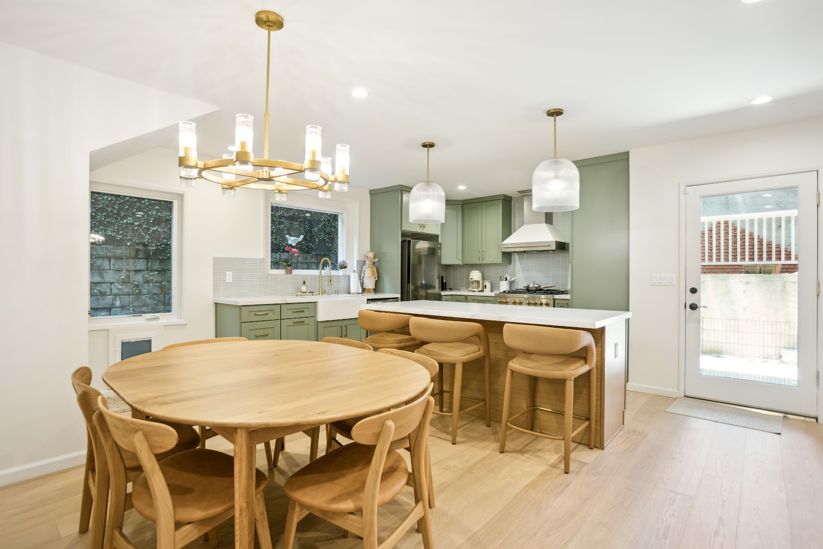 Whole house remodeling: sage green shaker kitchen and dining area under a vaulted ceiling